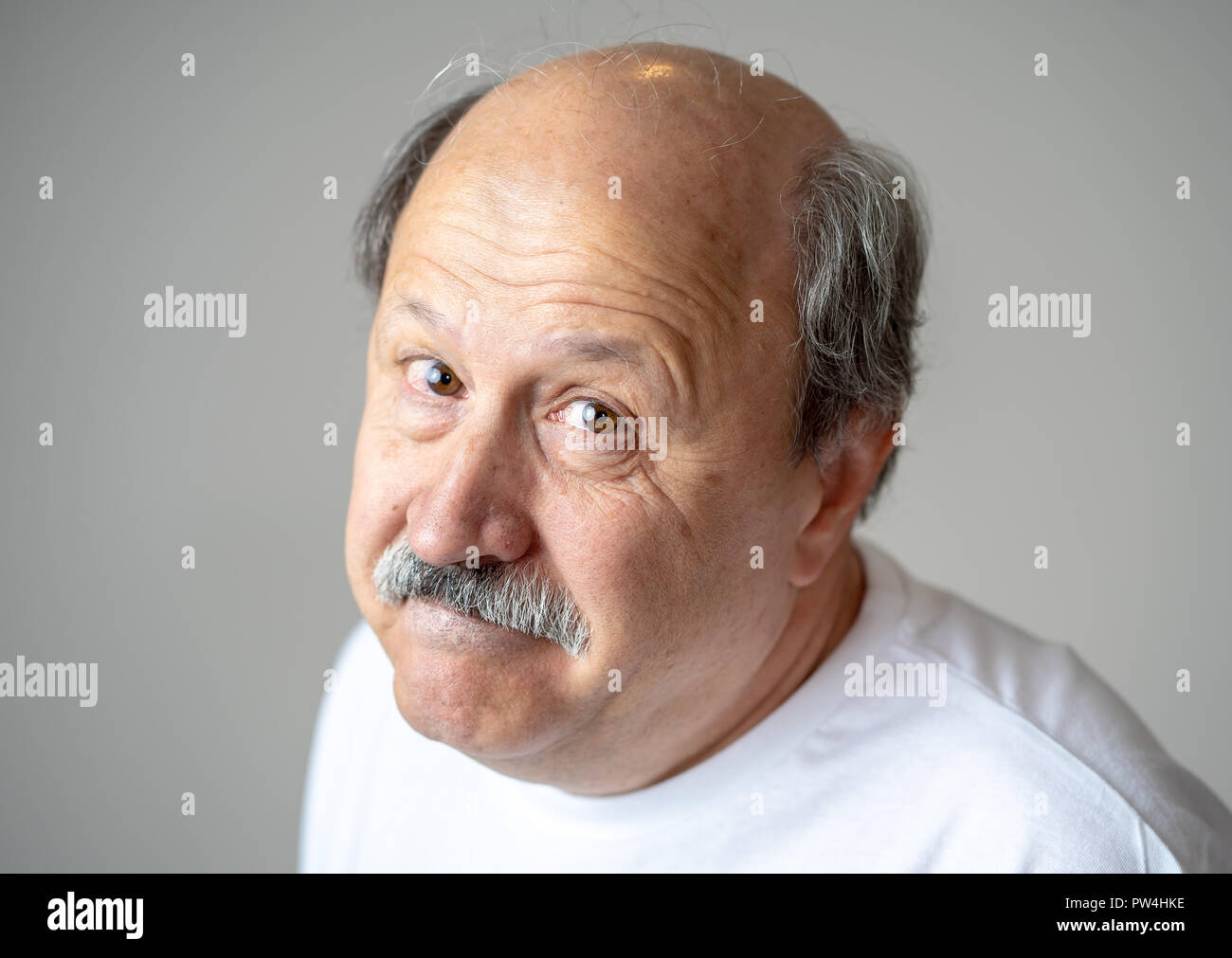 Portrait von älteren Erwachsenen älteren Mann in Schmerz mit traurig und erschöpft Gesicht in menschlichen Emotionen Gesichtsausdruck in den Ruhestand und Depression Konzept isoliert Stockfoto