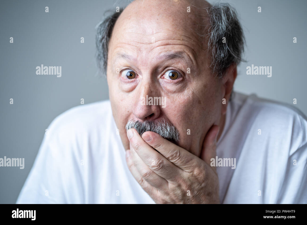 Nahaufnahme, Porträt einer Angst Angst alter Mann im Ausdruck der Angst in der menschlichen Emotionen und Gesichtsausdrücke in neutralen Hintergrund isoliert. Stockfoto