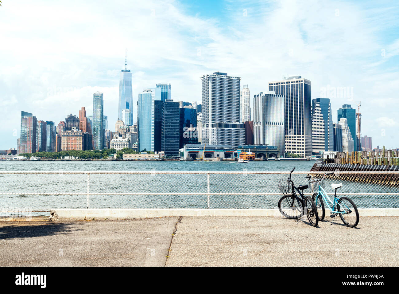 Moderne Gebäude, die von Governors Island gegen bewölkten Himmel in der Stadt Stockfoto