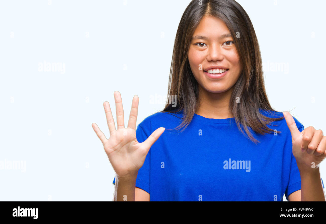 Junge asiatische Frau über isolierte Hintergrund angezeigt und zeigen mit den Fingern Nummer sechs, während lächelte zuversichtlich und fröhlich. Stockfoto