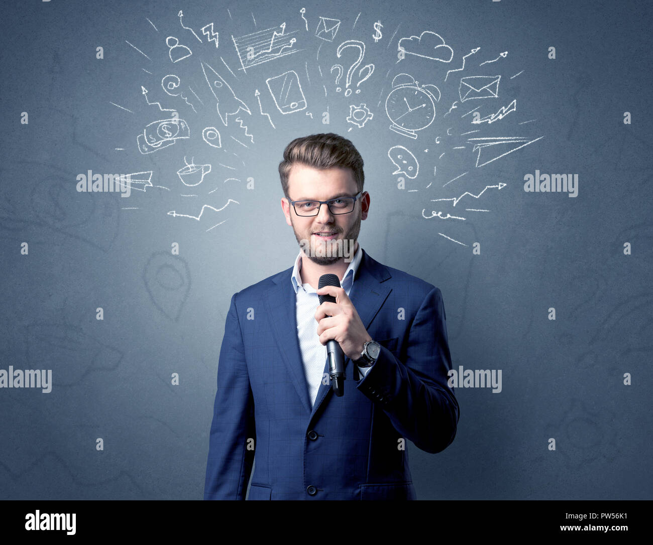 Geschäftsmann sprechen in das Mikrofon mit gemischten Doodles über seinem Kopf Stockfoto