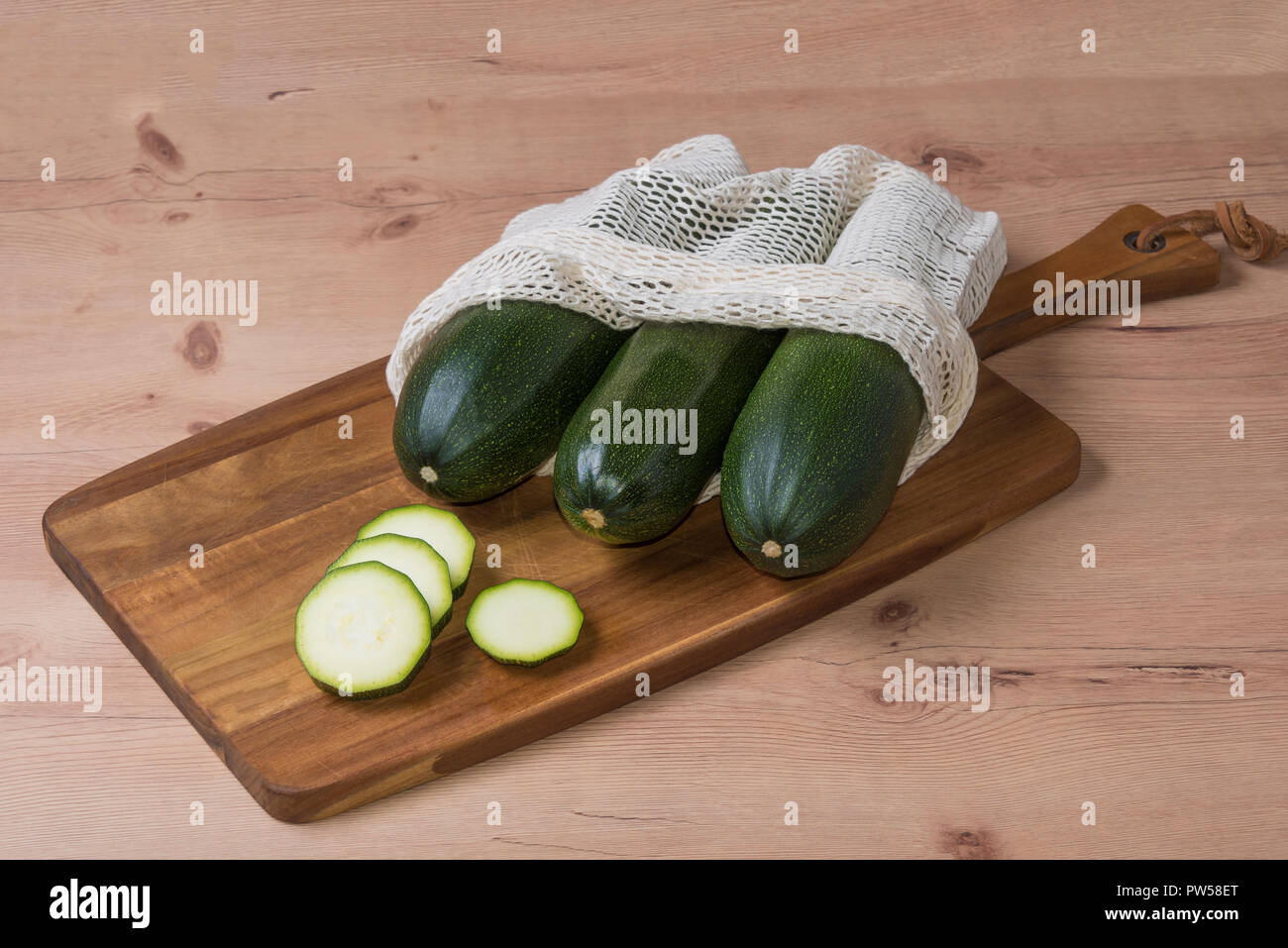 Frische organische, Bio natürliche Gurke aus meinem Garten auf hölzernen Tisch in ganzen und Schnitt in zero waste Bag in Scheiben geschnitten, nein zu sagen, Kunststoff Stockfoto