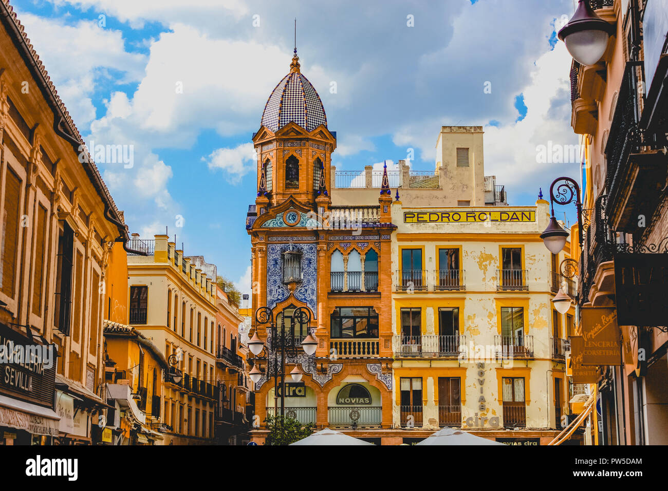 Schönes Gebäude mit roten, blauen, weißen und gelben Fassaden in Sevilla, Spanien Stockfoto