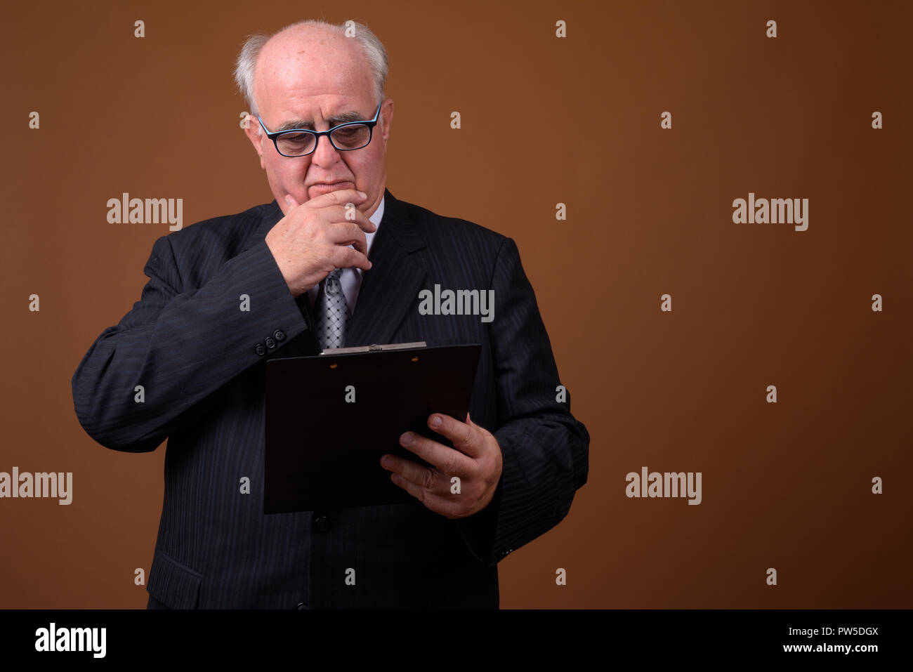 Portrait von Übergewicht älterer Geschäftsmann mit Zwischenablage Stockfoto