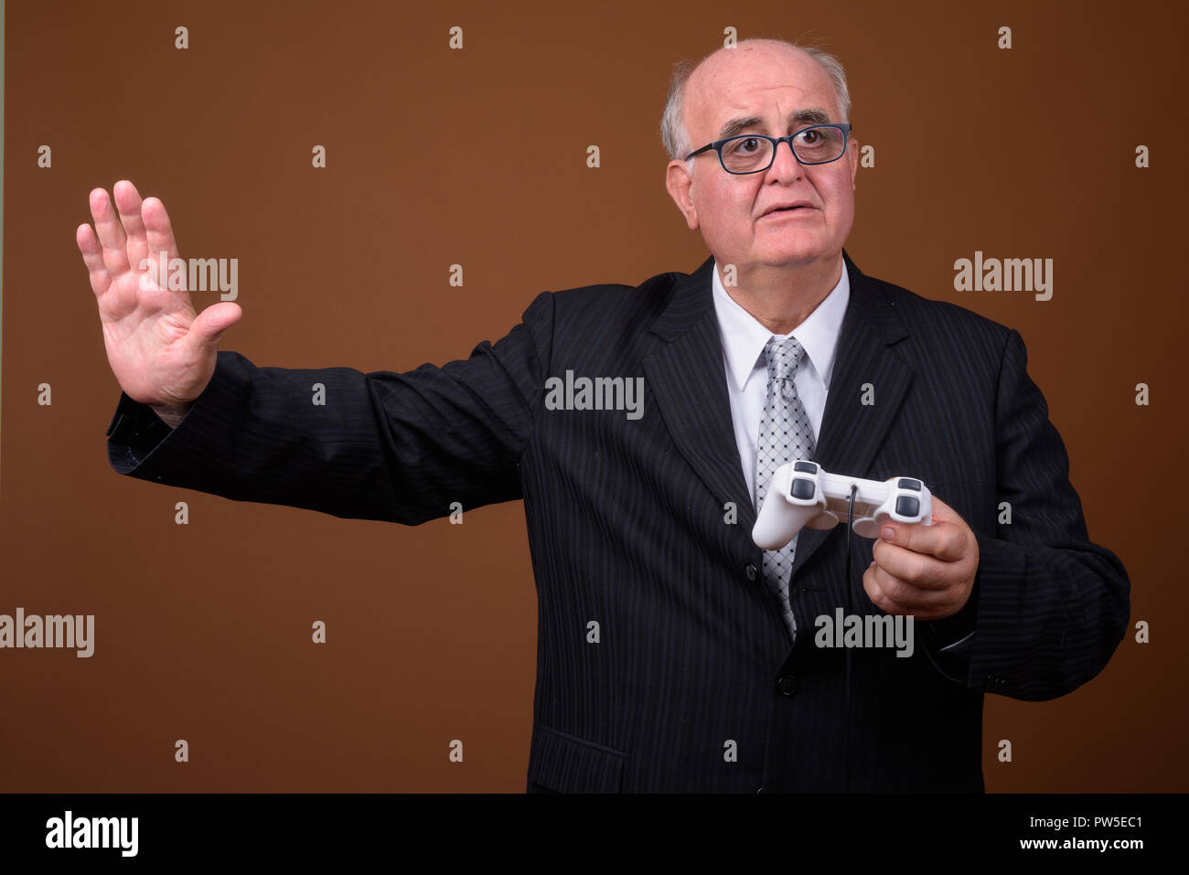 Übergewicht älterer Geschäftsmann spielen und der Holding Game Controller Stockfoto