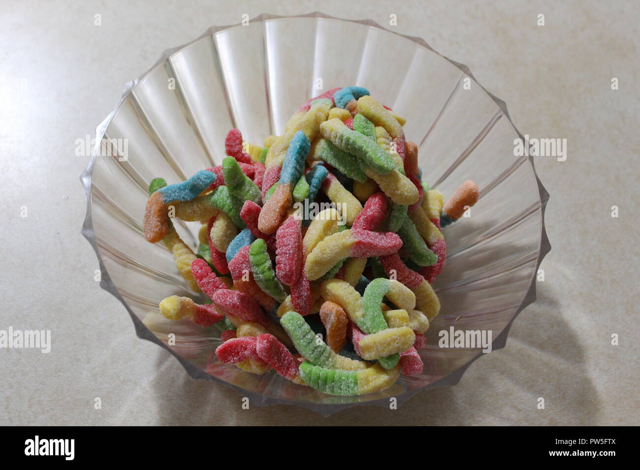 In der Nähe von Gummibärchen Worms in einer Plastik Schüssel serviert auf einem weißen Tisch Stockfoto