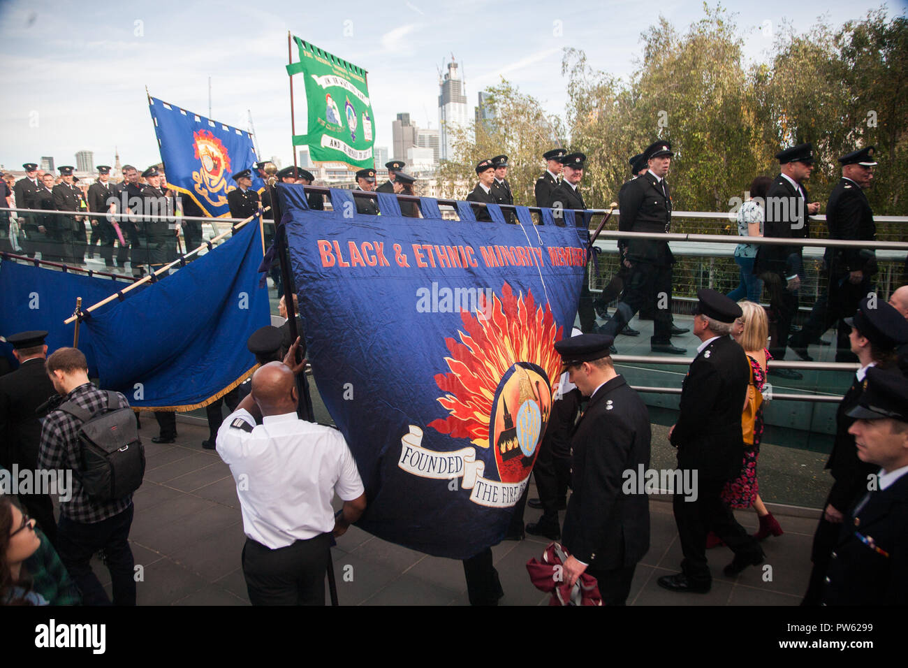 London UK. 13. Oktober 2018. Vertreter aus jedem FBU Löscheinsatz der Feuerwehr März über die Millennium Bridge zu Southwark Cathedral nach einer Kranzniederlegung für die Gefallenen Kollegen an den nationalen Feuerwehrmänner Memorial, St. Pauls auf das 100-jährige Jubiläum der Feuerwehr Union Credit: Amer ghazzal/Alamy leben Nachrichten Stockfoto