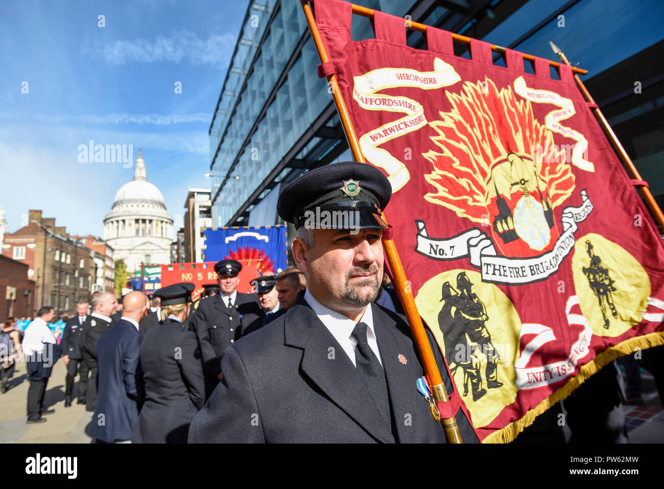 London, Großbritannien. 13. Oktober 2018. Nach einem förmlichen Kranzniederlegung am Nationalen Feuerwehrmänner' Memorial neben der St. Paul's Cathedral, in Erinnerung an gefallene Feuerwehrmänner aus allen Feuerwehr in Großbritannien, Mitglieder der Feuerwehren Union (FBU) Teil in einer formellen Prozession über die Millennium Bridge nehmen, gefolgt von einem Service in Southwark Kathedrale den 100. Jahrestag der Gründung der FBU zu gedenken. Die Aktivitäten sind die bisher größte Festveranstaltung für Feuerwehrmänner, die in der Linie der Aufgabe getötet. Credit: Stephen Chung/Alamy leben Nachrichten Stockfoto