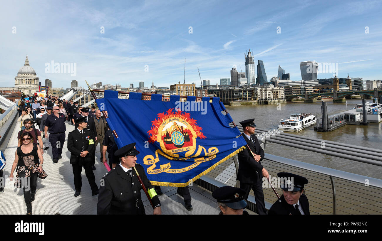 London, Großbritannien. 13. Oktober 2018. Nach einem förmlichen Kranzniederlegung am Nationalen Feuerwehrmänner' Memorial neben der St. Paul's Cathedral, in Erinnerung an gefallene Feuerwehrmänner aus allen Feuerwehr in Großbritannien, Mitglieder der Feuerwehren Union (FBU) Teil in einer formellen Prozession über die Millennium Bridge nehmen, gefolgt von einem Service in Southwark Kathedrale den 100. Jahrestag der Gründung der FBU zu gedenken. Die Aktivitäten sind die bisher größte Festveranstaltung für Feuerwehrmänner, die in der Linie der Aufgabe getötet. Credit: Stephen Chung/Alamy leben Nachrichten Stockfoto