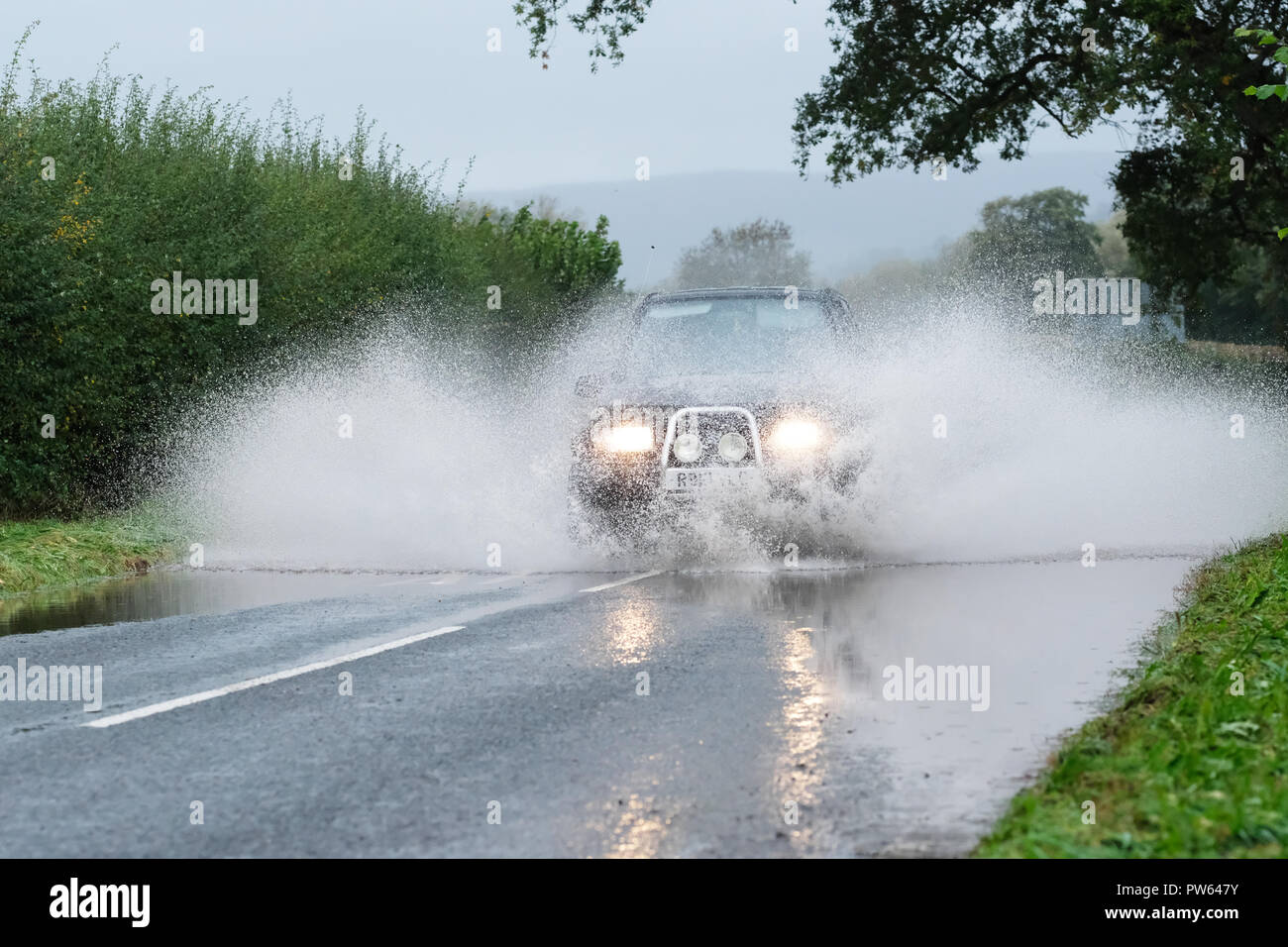 Brede, Powys, Wales - Am Samstag, den 13. Oktober 2018 - Ein 4WD Auto fährt durch Überschwemmungen auf der Straße bei Crickhowell nach sintflutartigen Regenfällen während Sturm Callum - der angrenzenden Fluss Usk hat die Ufer. Foto Steven Mai/Alamy leben Nachrichten Stockfoto