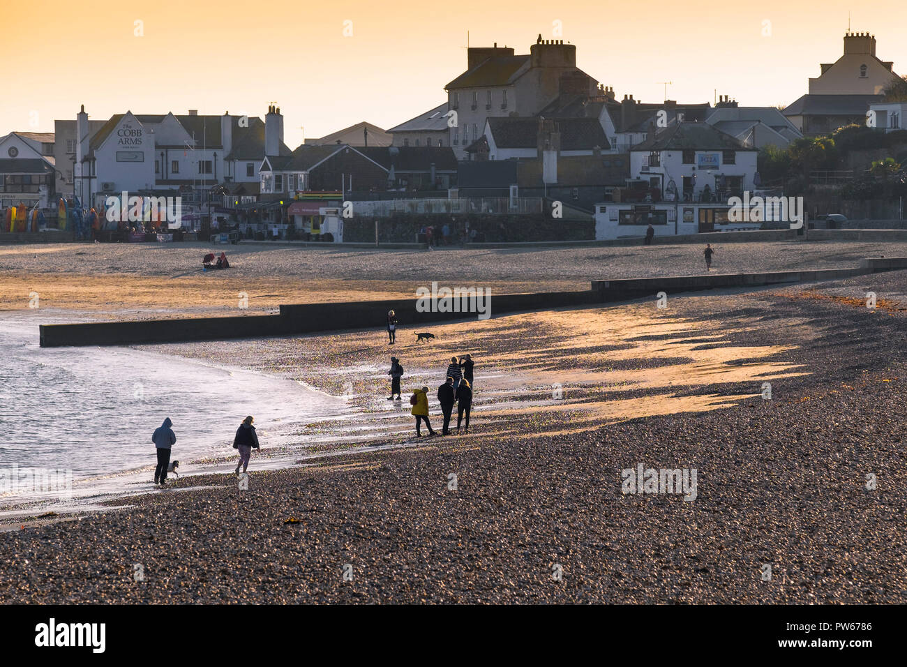 Urlauber an der Küste von Lyme Strand bummeln in der Küstenstadt von Lyme Regis in Dorset. Stockfoto