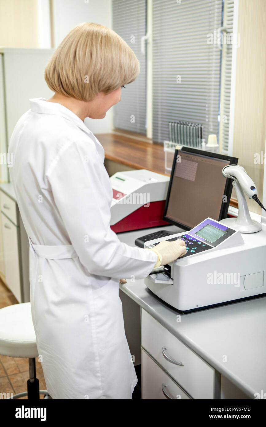 Laboratory Assistant wählt den Modus für den Betrieb der Geräte für die Analyse von Proben Stockfoto