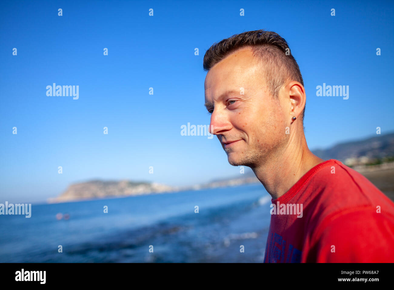 ALANYA/TÜRKEI - SEPTEMBER 30,2018: Ein deutscher Mann sitzt auf einer Küste in Anlanya Stockfoto