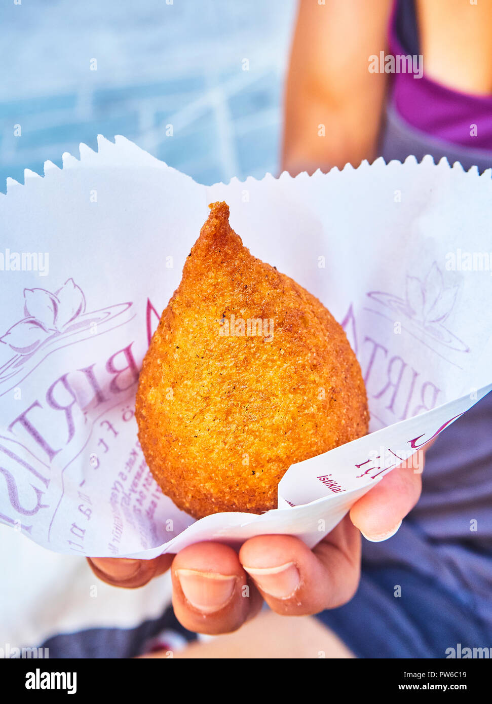 Eine weibliche Hand mit einem icli Köfte, ein traditionelles Gericht der arabischen Küche. Auch als Kibbeh, Kibbe, Kibe, Kipe, Kibba, Kubbah, Kobeiba oder Quibbe bekannt. Stockfoto