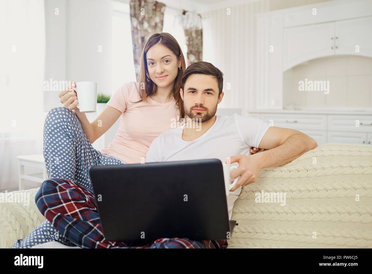 Der Mann und die Frau mit einem Laptop lesen, zu Hause zu sitzen. Stockfoto