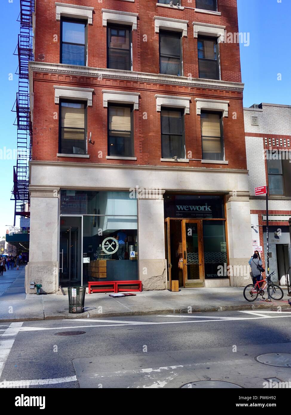 Die Außenseite des typischen alten Backsteingebäude mit externer Brand entkommt, Gehäuse WeWork Büros, Grand Street, New York, NY, USA. Stockfoto