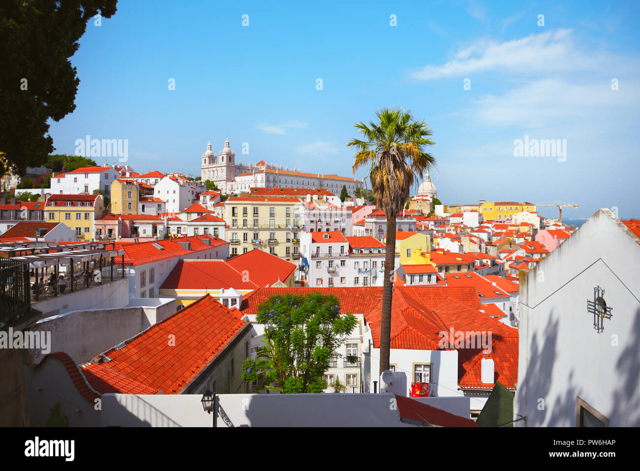 Luftaufnahme von Alfama, Lissabon an einem hellen Tag mit orange-roofed weißen Gebäuden und Palmen. Stockfoto