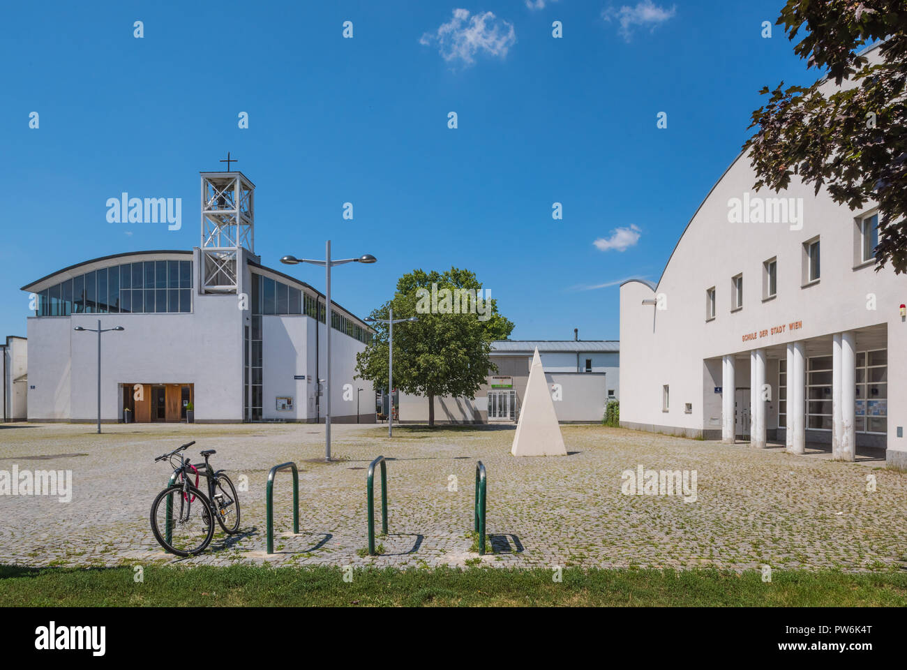 Wien, Tesarekplatz, links Pfarrkirche Emmaus am Wienerberg, Architekt Otto Häuselmayer 1992, rechts Schule, Architekt Gustav Peichl Stockfoto