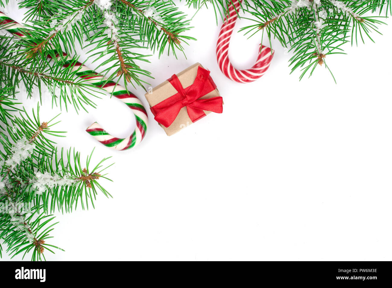 Weihnachten Rahmen der Fir Tree Branch mit Zuckerstangen und Schnee auf weißem Hintergrund mit Kopie Platz für Ihren Text isoliert Stockfoto
