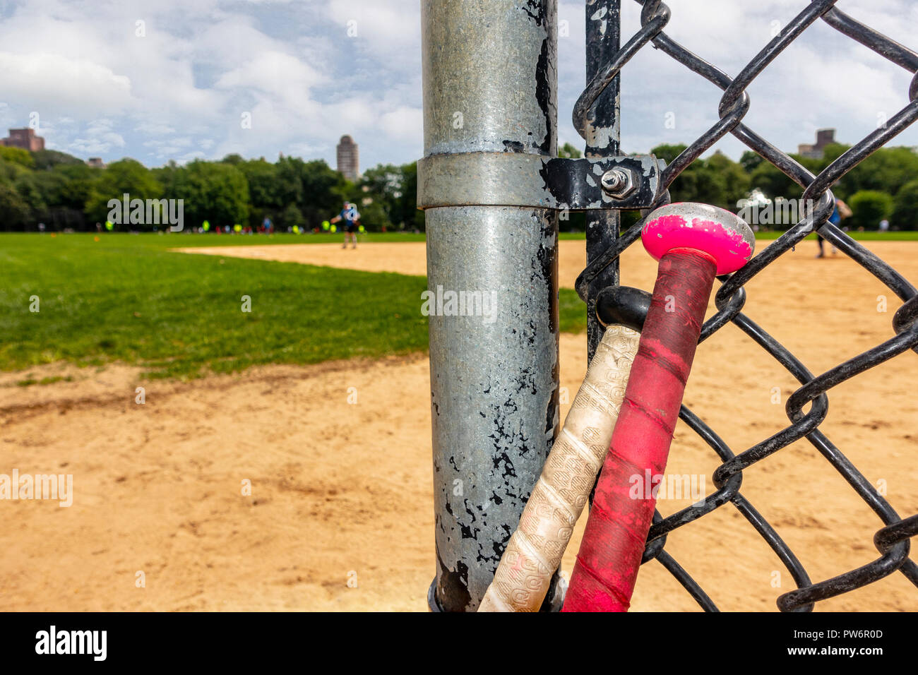 Zwei Fledermäuse an einem Baseball Diamond lehnte sich auf bating Zaun Stockfoto