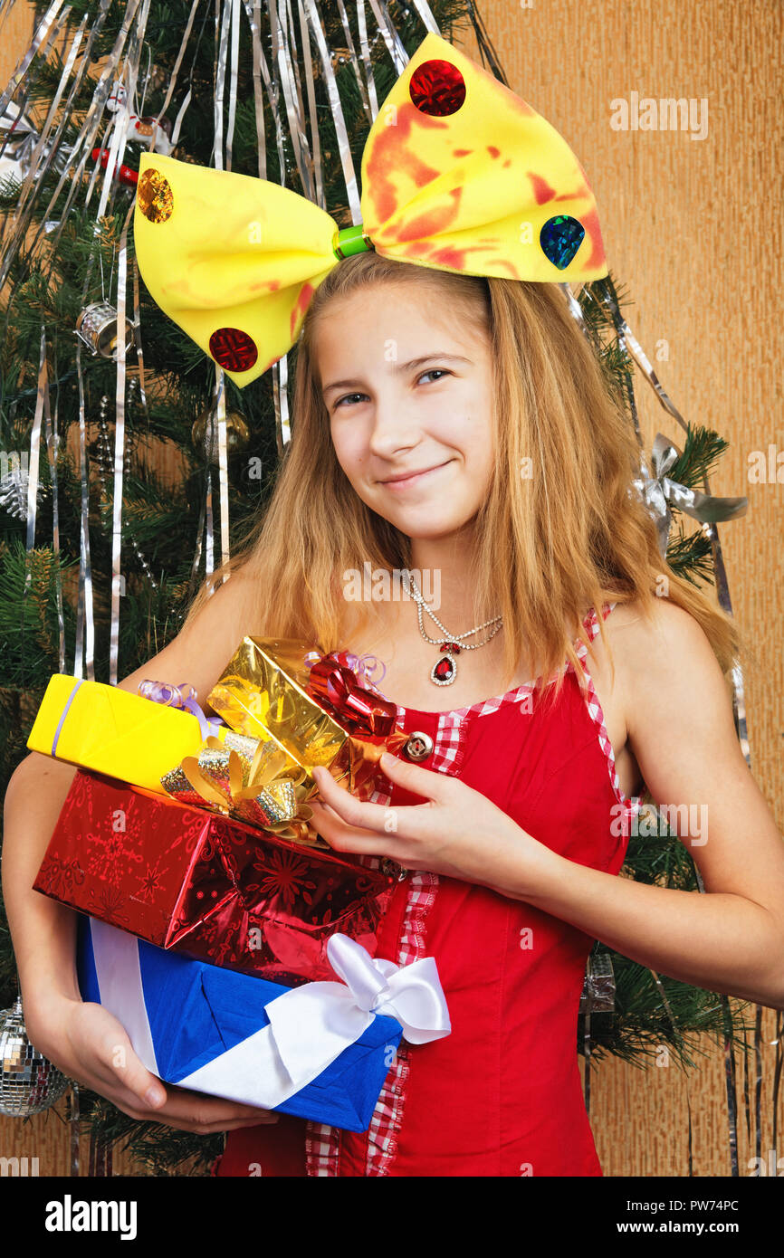 Happy Teen Girl Holding mehrere Weihnachtsgeschenke in einem hellen Paket Stockfoto