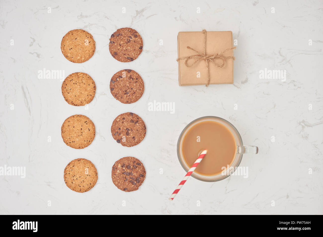 Hintergrund mit Chocolate Chip Cookies, Milch, Kaffee und Geschenk. Flach. Ansicht von oben. Stockfoto