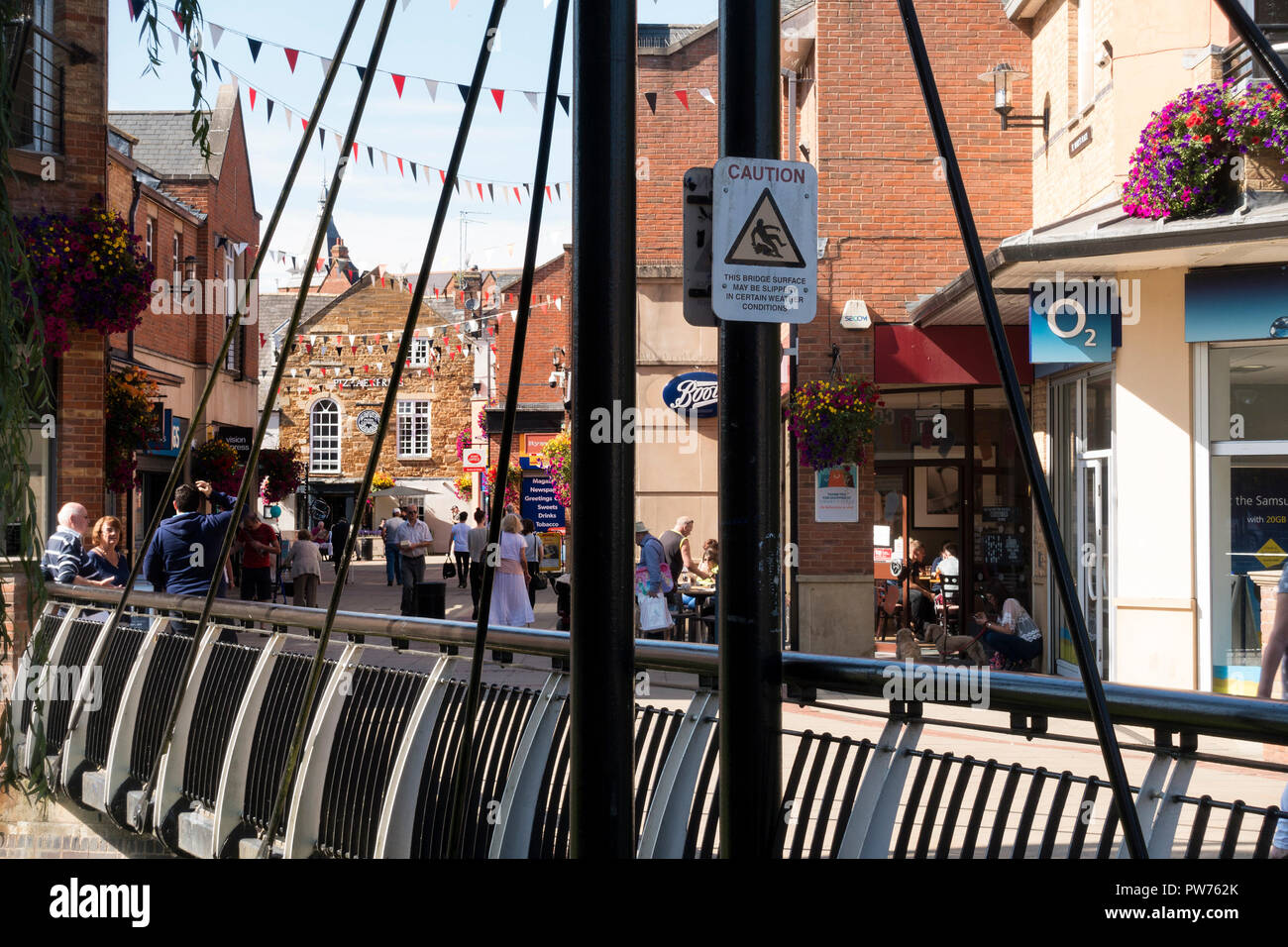 Metall Brücke über den Fluss Welland und Käufer an St. Mary's Place Shopping Center, Market Harborough, Leicestershire, England, Großbritannien Stockfoto