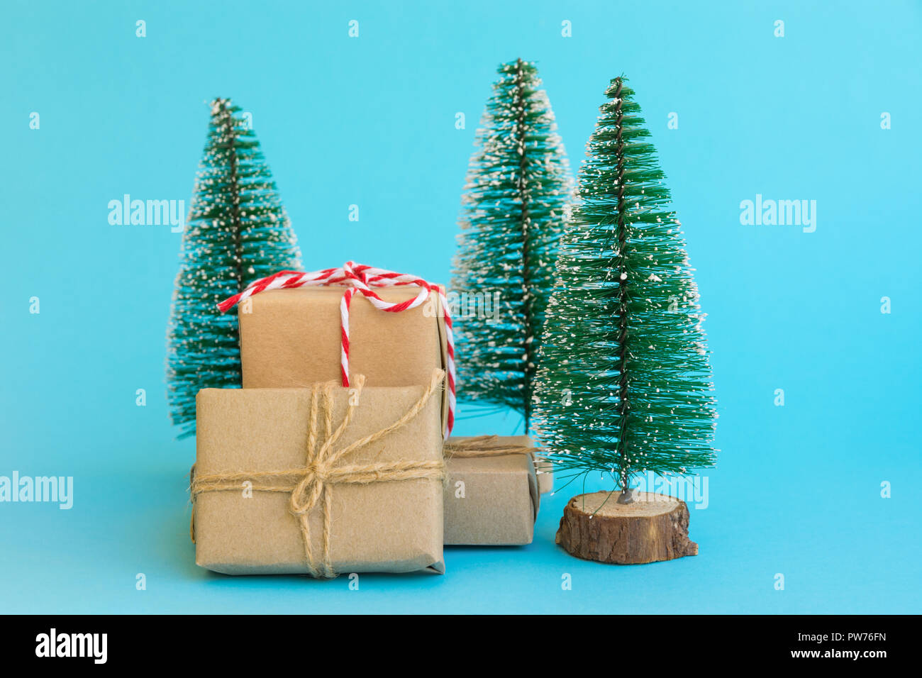 Stapel der Geschenkboxen in Handwerk Papier mit Garn rot weiße Band Weihnachtsbäume auf Mint blau hintergrund Band umwickelt. Neues Jahr corporate präsentiert shoppi Stockfoto