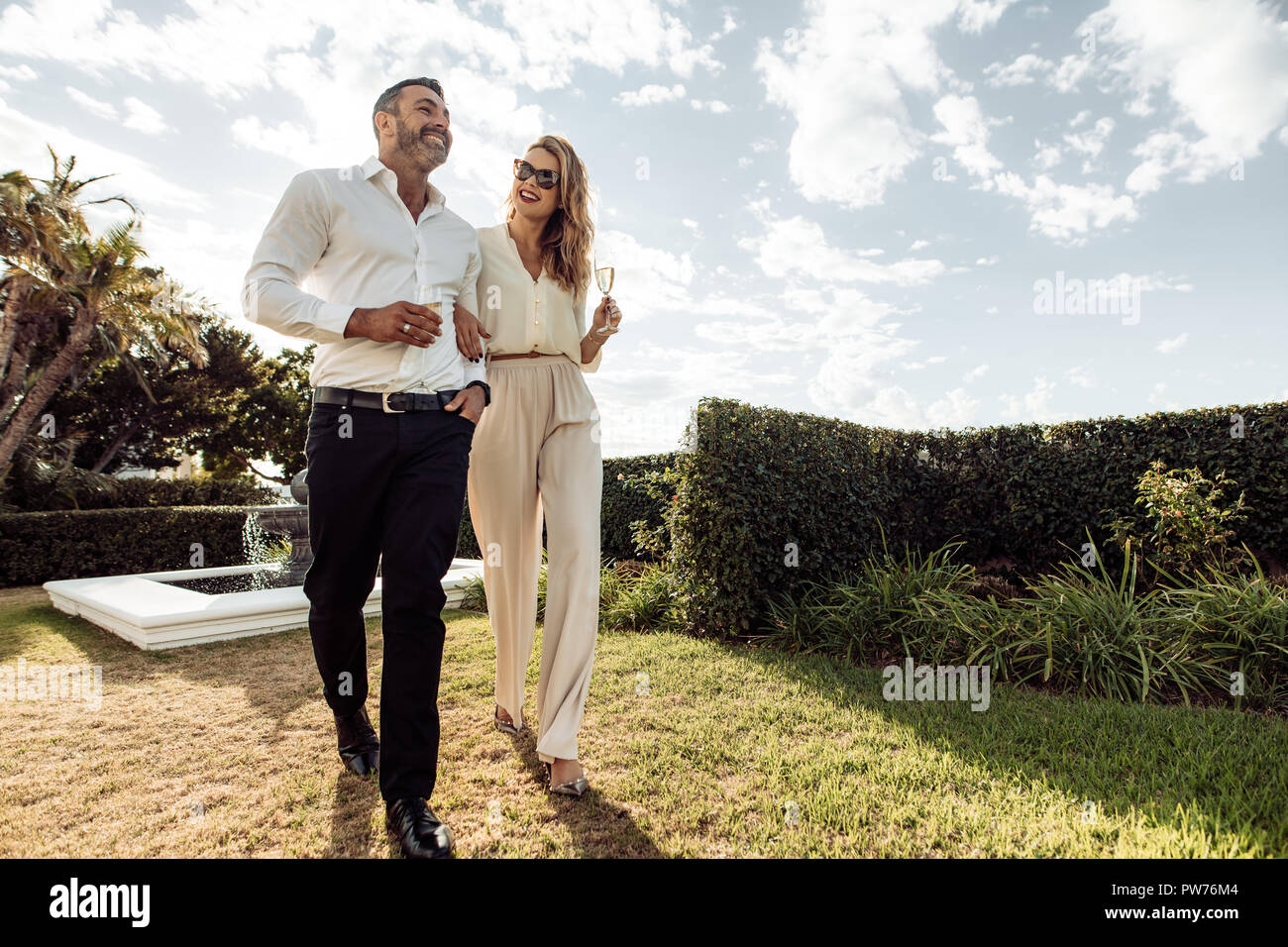 Paar mit einem Glas Wein und genießen Sie jede andere Firma. Der Mann und die Frau mit einem Getränk und Spaß im Freien. Stockfoto