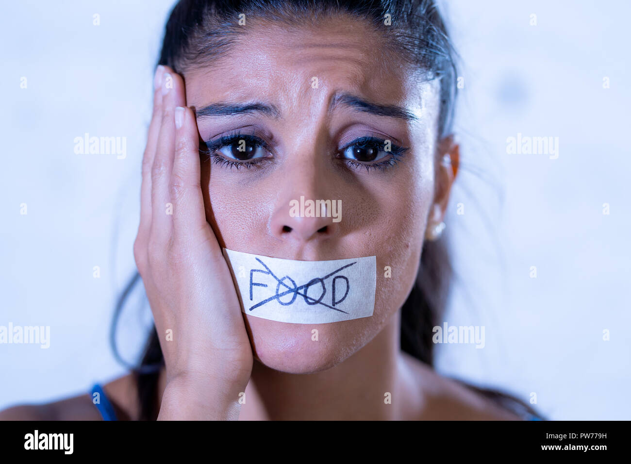 Nahaufnahme, Porträt der jungen attraktiven Latein Frau mit Mund auf Klebeband mit Text keine Lebensmittel in der Ernährung Magersucht Essstörungen Konzept versiegelt. Stockfoto