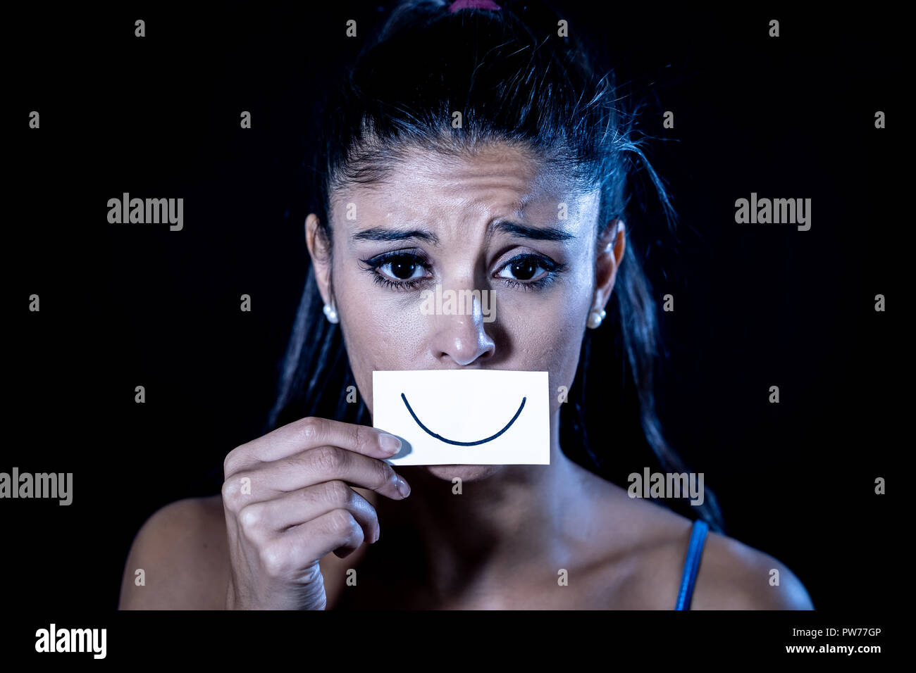 Dramatische Nahaufnahme Portrait von traurige Frau ihre Depression verstecken mit Lächeln auf Papier in der menschlichen Emotion leiden in der Stille depression Konzept iso lackiert Stockfoto