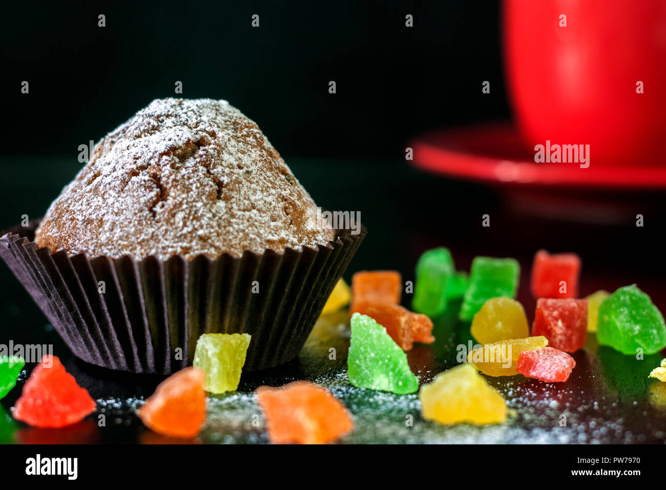 Frisch gebackene Muffins mit kandierten Früchten auf einem Schwarzen Tisch Stockfoto