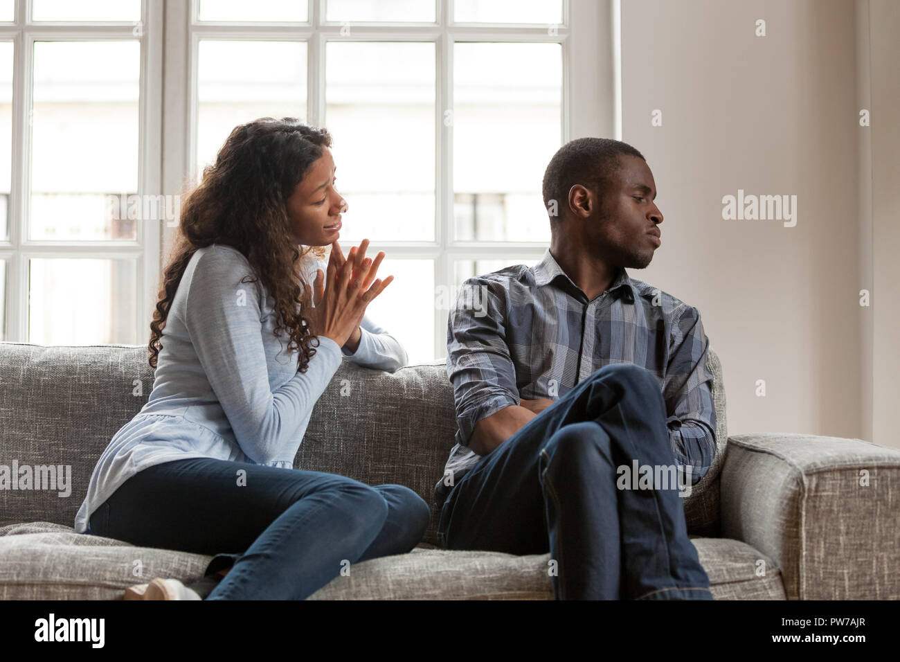 Wütend Mann und schuldig Frau sitzt auf der Couch zu Hause Stockfoto