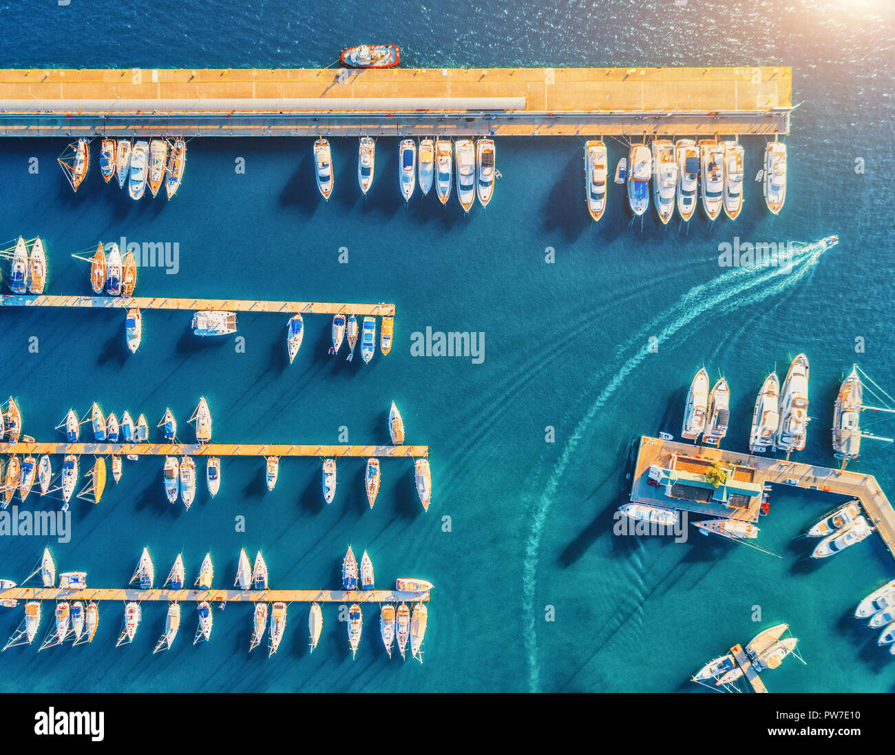 Luftaufnahme von erstaunlichen Boote bei Sonnenuntergang. Minimalistischer Landschaft mit Boote und Meer in Marina Bay. Ansicht von oben von drohne von Hafen mit Yacht, Motorboot ein Stockfoto