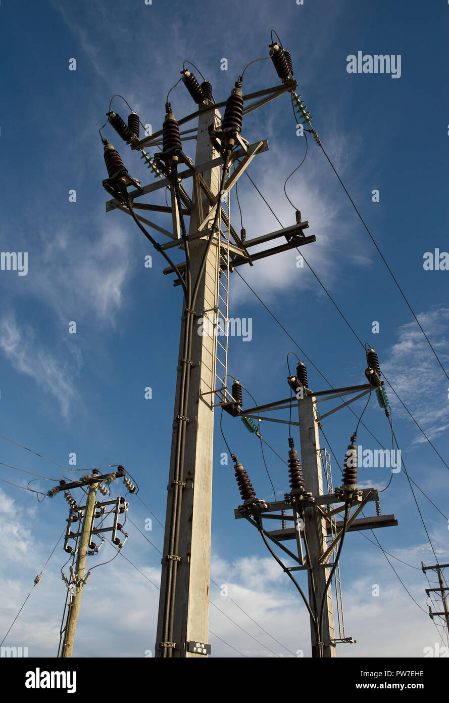 Drei elektrischen Strommasten Versorgung gegen einen blauen Morgenhimmel. Stockfoto