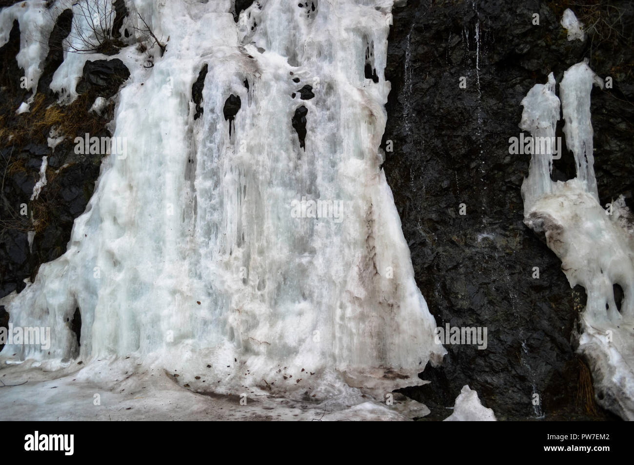 Gefrorenes Eis im Winter auf der Seite eines Berges. Stockfoto
