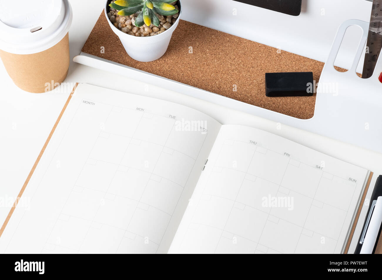 Ansicht von oben öffnen Sie Kalender Planer mit modernen Büro- und Schreibwaren, und nehmen Sie die Kaffeetasse auf weißem Schreibtisch im Büro. Mock up Raum des Veranstalters Tabelle beachten Stockfoto