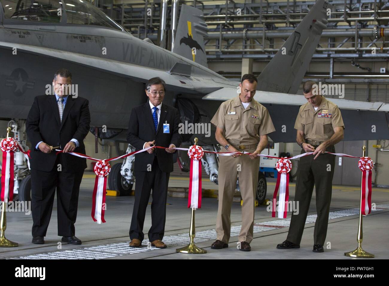 Von links nach rechts, James Bock, F/A-18 Super Hornet geplanten Wartungsintervall line Programm Manager mit Flotte Readiness Center Western Pacific (FRCWP), Tomoshi Kometani, General Manager von nippi Corporation Wartung Division, U.S. Navy Capt. Matthew Edwards, kommandierender Offizier der FRCWP und US Marine Corps Oberst Mark Palmer, kommandierender Offizier der Marine Aircraft Group (MAG) 12 mit einem "Ribbon Cutting teilnehmen an der Marine Corps Air Station Iwakuni, Japan, Sept. 22, 2017. Die Zeremonie gefeiert Iwakuni FRCWP Loslösung der Induktion der ersten Flugzeuge für die Wartung in der Einheit " Stockfoto