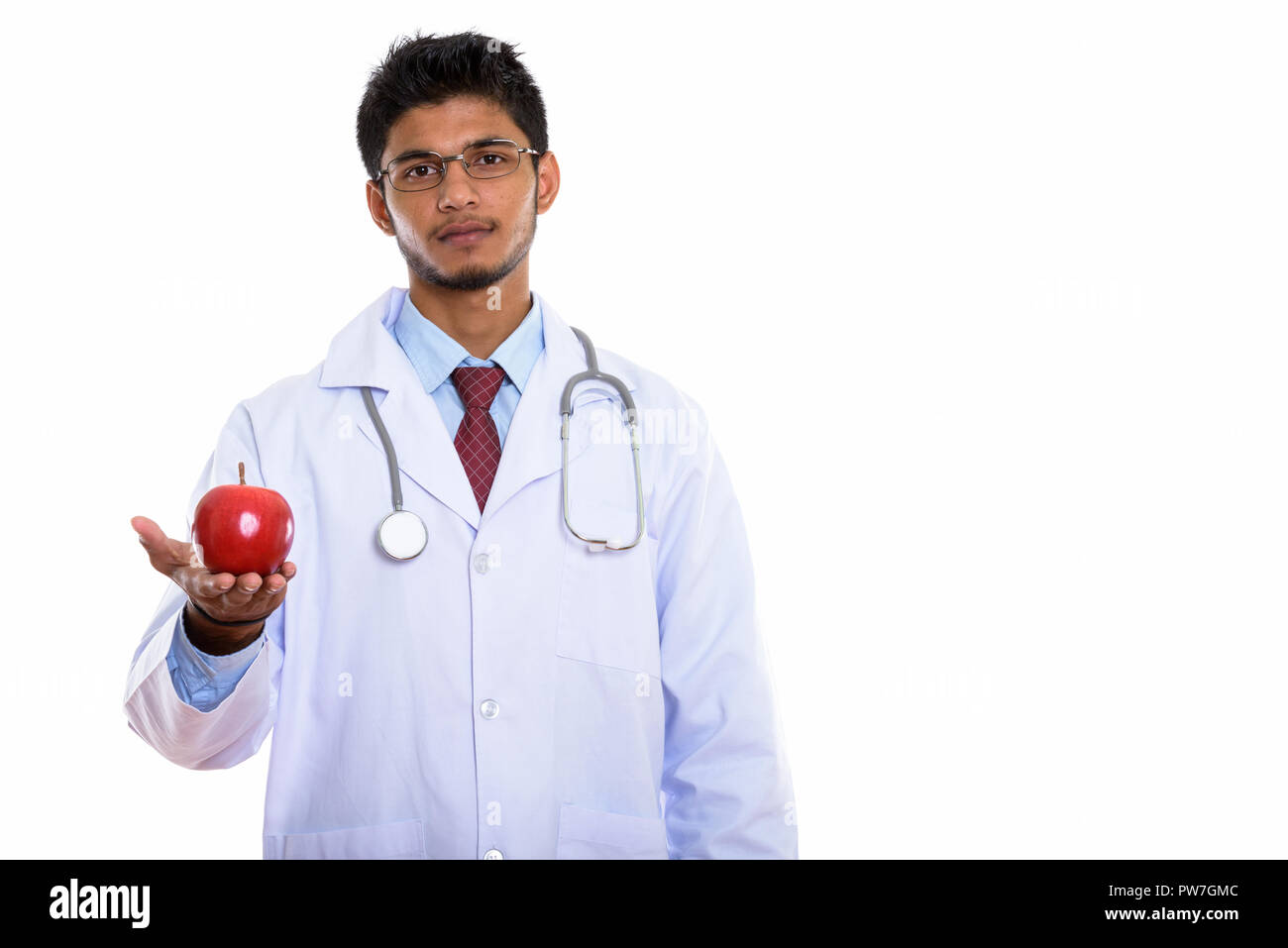 Studio shot der jungen schönen Indischen mann Arzt halten roten Appl Stockfoto
