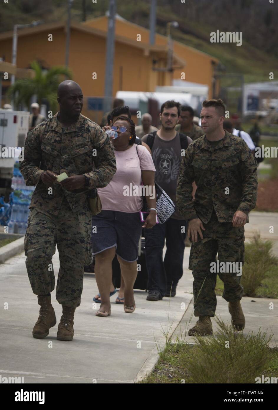 Us-Marines Staff Sgt. Christopher K. Bamfo und Gunnery Sgt. Philip C. Sakett, mit Joint Task Force - Leeward Inseln, Escort US-Bürger von der Evakuierung Control Center zu den Flug Linie an Douglas-Charles Flughafen in Dominica, Sept. 24, 2017. Das Control Center wurde eingerichtet, die in den freiwilligen Evakuierung von US-Bürgern auf Dominica gestrandet nach Hurrikan Maria zu unterstützen. Auf Anfrage der Partnerländer und sowohl das State Department und der US-Agentur für Internationale Entwicklung, JTF-LI hat Flugzeuge und Service Mitglieder zu den Bereichen in der östlichen Karibik bereitgestellt von Hu Stockfoto