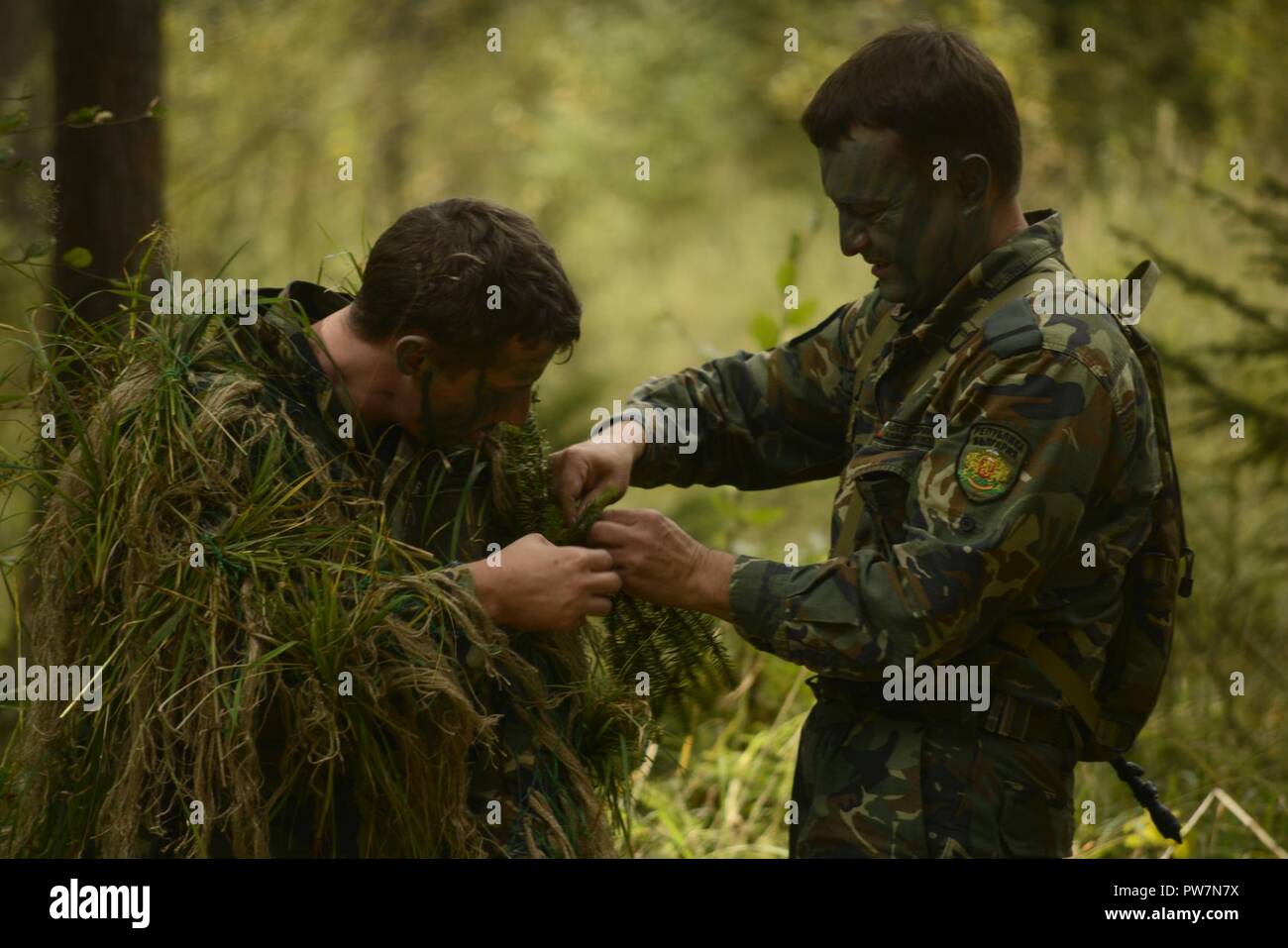 Bulgarische Soldaten helfen einander ihre tarnanzügen durch Klagen beim Europäischen beste Sniper Squad Konkurrenz an der 7th Army Training Befehl Grafenwöhr Training Area, Germany, Sept. 26, 2017 Machen Sie sich bereit. Die Europäische beste Sniper Squad Wettbewerb ist eine US-Armee Europa Konkurrenz, anspruchsvolle Militärs aus ganz Europa zu konkurrieren und die Zusammenarbeit mit Verbündeten und Partner Nationen verbessern. Der Wettbewerb ist Multinationale durch Design und betrifft Geräte aus 14 Ländern. Stockfoto