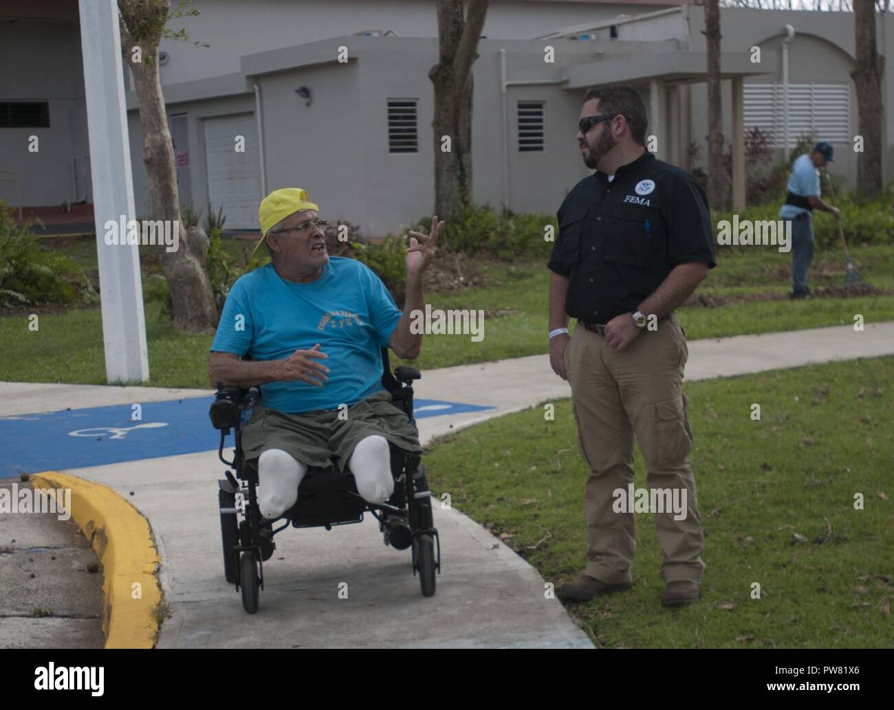 Daniel Llargues, einer externen Angelegenheiten Offizier mit FEMA, diskutiert mit einem Mieter eines älteren lebenden Werk Oktober 3, 2017, in Carolina, Puerto Rico. Llargues war die Unterstützung einer der FEMA Disaster survivor Hilfe Teams, die auf dem Gebiet der Registrierung disaster Überlebenden und Organisationen zu ermitteln, in denen Ressourcen wie Nahrung, Wasser, Kraftstoff, und Generatoren am besten verteilt werden können. Stockfoto