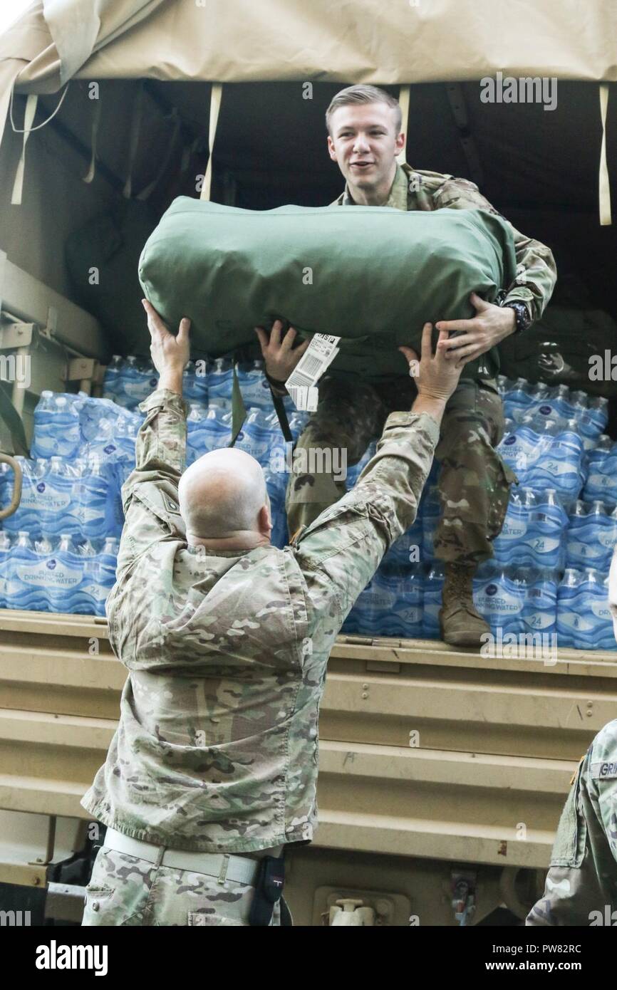 Ohio National Guard Soldaten der 285. Medical Unternehmen (Bereich Support) Last Wasser und Mission erforderliche Ausrüstung auf eine Light Medium Tactical Vehicle (LMTV) Oktober 3, 2017, in Vorbereitung auf die Bewegung zu Puerto Rico von Rickenbacker Air National Guard Base in Columbus, Ohio. Die Ohio National Guard und andere militärische Kräfte arbeiten gemeinsam daran, die zur Unterstützung der zivilen Behörden Hilfe und Erleichterung für die Betroffenen durch den Hurrikan Maria zur Verfügung zu stellen. (Ohio National Guard Stockfoto