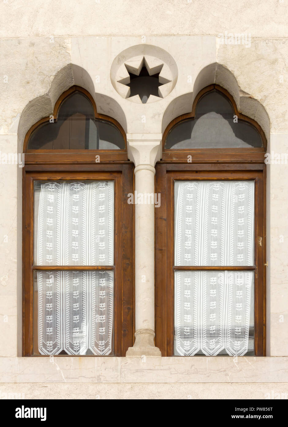 Fenster mit Fensterkreuz im venezianischen Stil in einem historischen Gebäude in Venzone, Italien Stockfoto