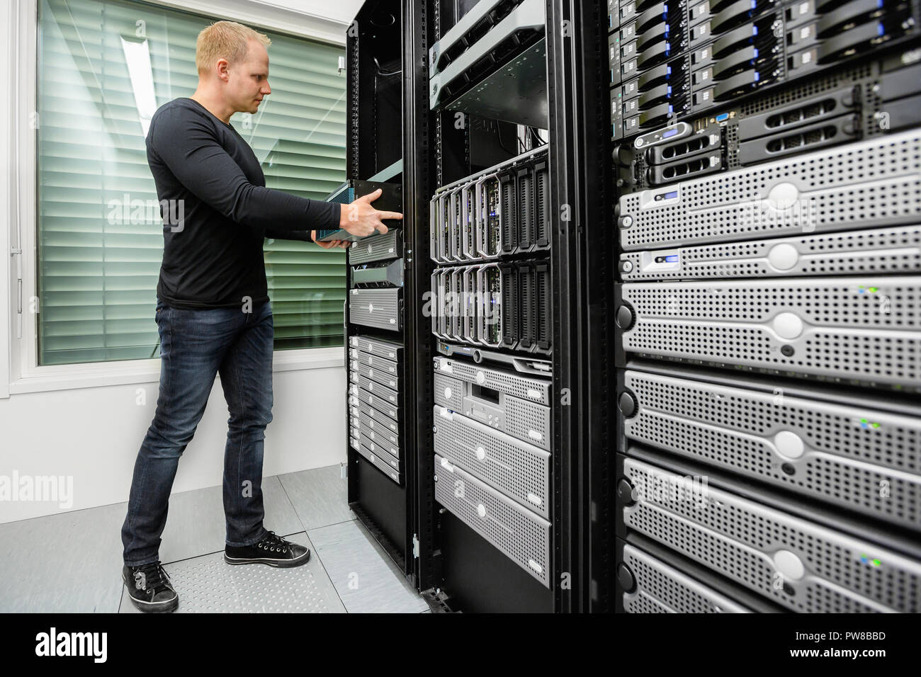 Männliche technischer Berater installieren Router in SAN im Rechenzentrum Stockfoto