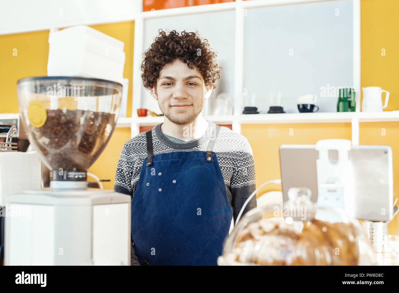 Gastfreundliche barista lächelnd und stand hinter der Theke. Stockfoto