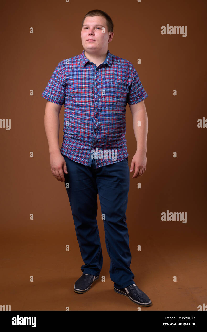Studio für übergewichtige junge Menschen gegen den braunen Hintergrund Stockfoto