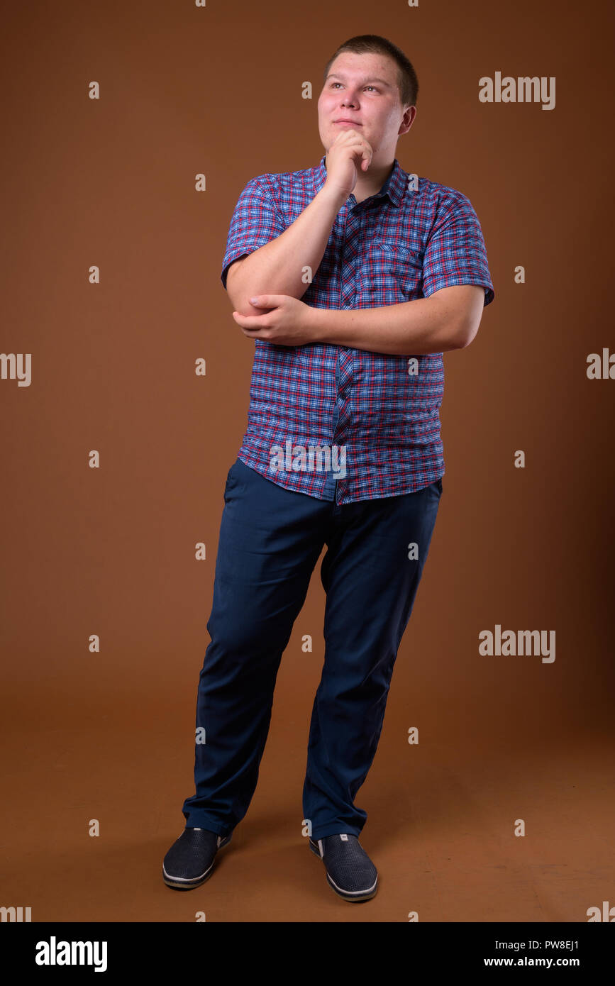 Studio für übergewichtige junge Menschen gegen den braunen Hintergrund Stockfoto