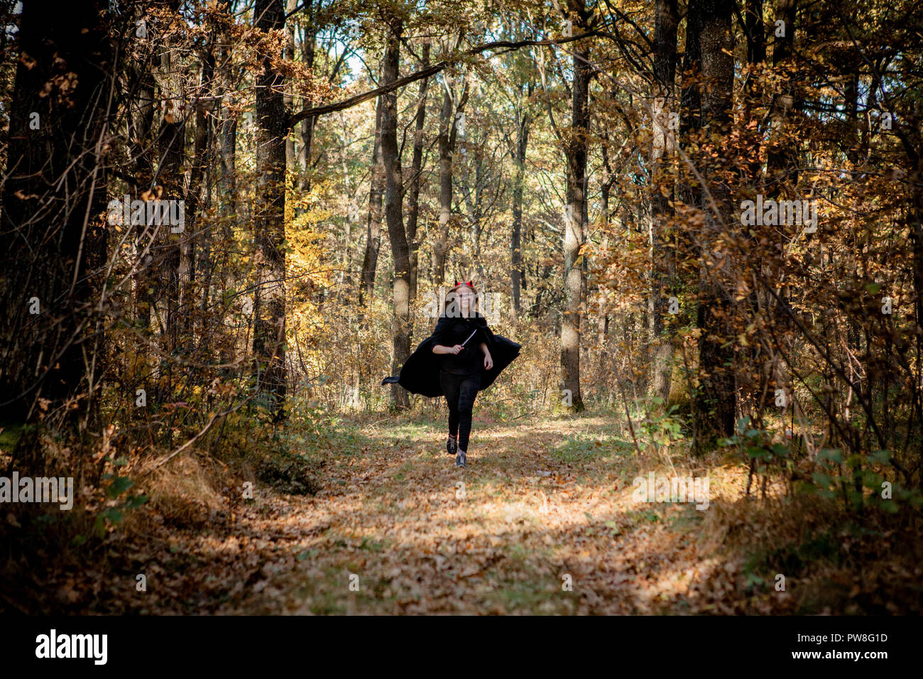 Halloween Dämon mit einem Messer läuft durch den Wald. Stockfoto