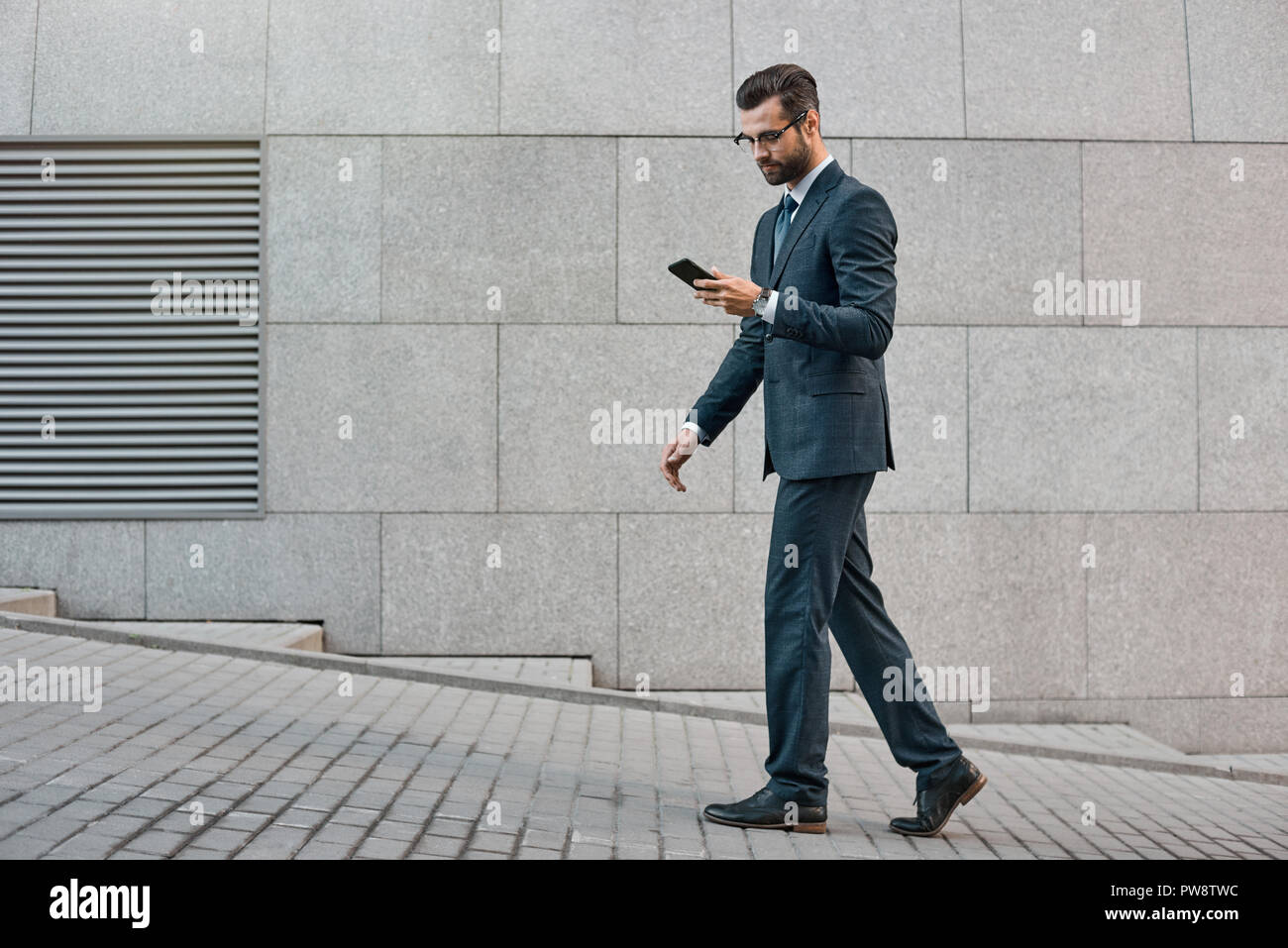 Elegante Geschäftsmann Hand halten und mit einem Smart Phone im Freien Stockfoto